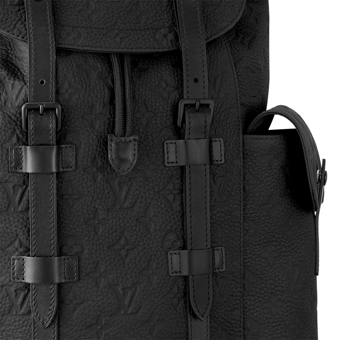Close-up of a black textured backpack with leather straps on a white background